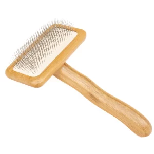 This image showcases a professional-grade slicker brush for dogs. The brush boasts a durable bamboo handle ergonomically designed for comfortable use, while the densely packed, fine-wire pins gently yet effectively remove mats, tangles, and loose fur from your dog's coat. The slicker brush for dogs is a must-have for any dog owner seeking to maintain their pet's coat health and shine. Its sturdy construction ensures long-lasting use.
