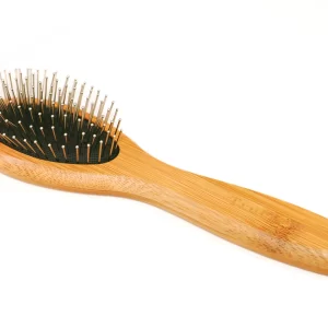 Showcasing its elegant form against a clean white background, this image details the bamboo pin brush for dogs. The light wood handle, black cushioned base, and rounded-tip metal pins are all visible, emphasizing a tool designed for both effectiveness and your pet's ultimate comfort during use.