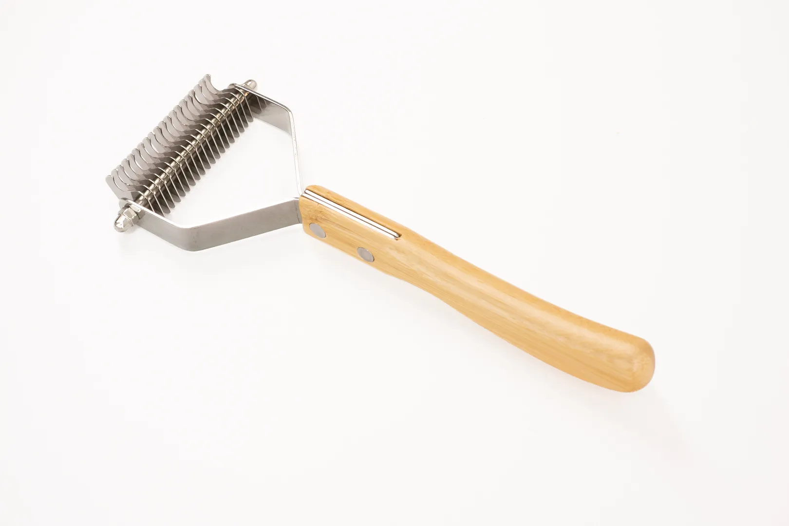 This image presents the full design of our premium Dog Undercoat Rake. It features an ergonomic bamboo handle for a comfortable, secure grip and a robust stainless steel head. This tool is specifically designed to tackle heavy shedding in double-coated breeds, ensuring a healthy and well-maintained coat.