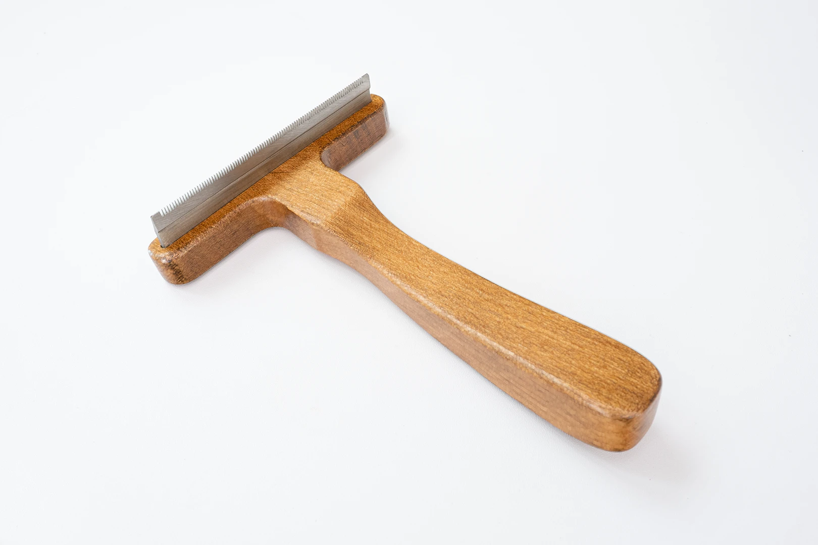 This photo displays the complete, ergonomic design of our wooden pet deshedding brush, ensuring a comfortable grip for an effortless and satisfying grooming experience.